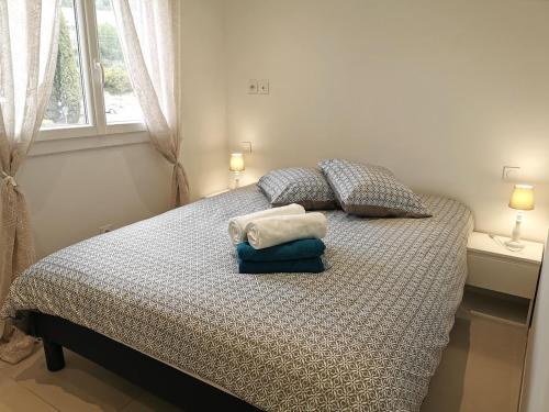 une chambre avec un lit avec des oreillers et une fenêtre dans l'établissement Appartement baie des anges vue sur mer, garage, à La Ciotat