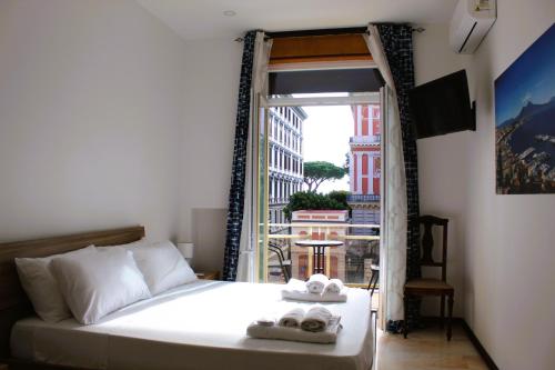 a bedroom with a bed and a door to a balcony at Punto Felice Riviera - Centro Città Lungomare Caracciolo in Naples
