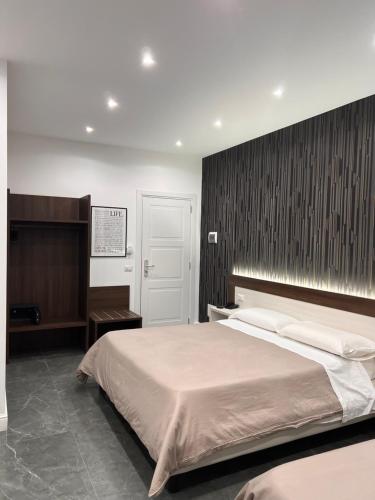 a bedroom with a large bed and a wooden wall at Hotel Blanc in Casoria