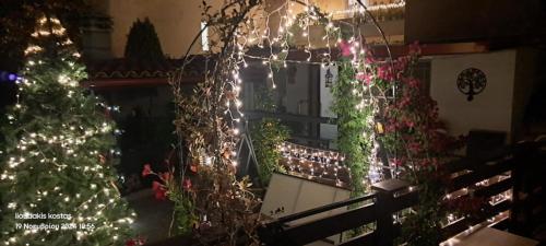 a balcony decorated with christmas lights and a christmas tree at Zoe garden home in Spáta