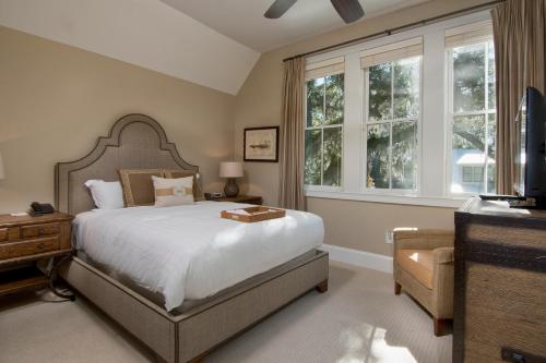 a bedroom with a bed and a tv and windows at Montage 3 Bedroom Wilson Village Home 5001 in Bluffton