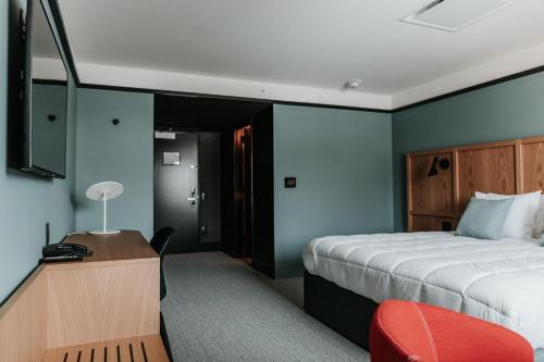 a hotel room with a bed and a desk and a chair at Haworth Hotel at Hope College in Holland