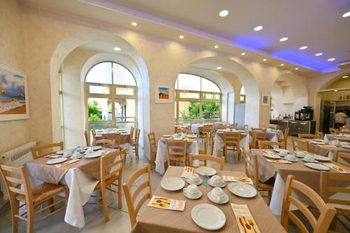 a restaurant with wooden tables and chairs and windows at Albergo Atlantic in Ischia