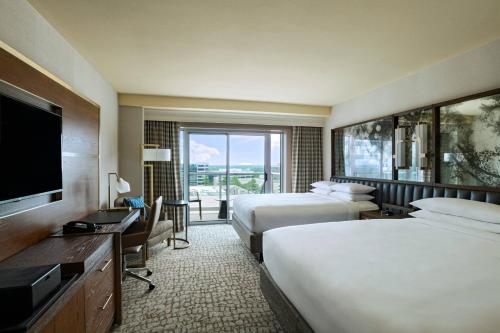 a hotel room with two beds and a flat screen tv at The Woodlands Waterway Marriott Hotel and Convention Center in The Woodlands