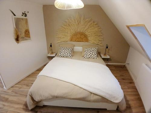 a bedroom with a large bed in a attic at Au Petit Wissant in Marquise