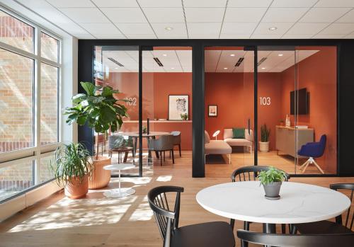 an office with orange walls and tables and chairs at Haworth Hotel at Hope College in Holland
