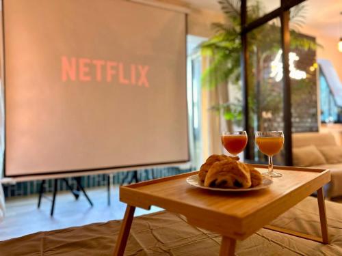 a table with a plate of food and two wine glasses at Splendide Loft avec Jacuzzi et Cinema - Cap d'Agde in Agde