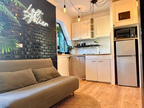 a living room with a couch and a kitchen at Splendide Loft avec Jacuzzi et Cinema - Cap d'Agde in Agde