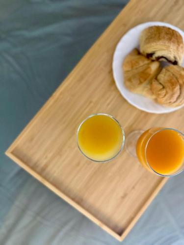 a tray with two cups of orange juice and a plate of food at Splendide Loft avec Jacuzzi et Cinema - Cap d'Agde in Agde