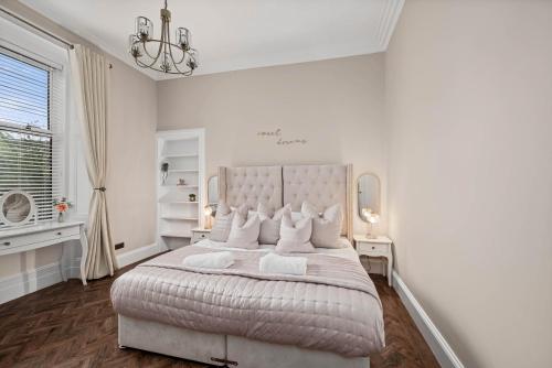 a white bedroom with a large bed and a window at Willowbank in Broughty Ferry