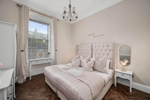 a white bedroom with a large bed and a window at Willowbank in Broughty Ferry