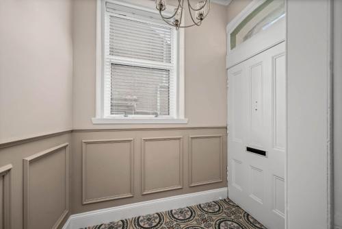 a hallway with a window and a white door at Willowbank in Broughty Ferry