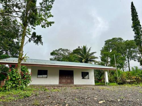 a small white house with a tree in front of it at Miravalles Country House in Guayabal