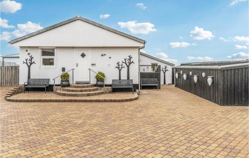 a white house with two benches and a fence at Stunning Home In Esbjerg V With Wifi in Esbjerg