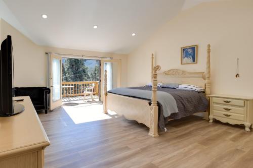Un dormitorio con una cama y un balcón. en Game Room and Deck Modern Frazier Park Home!, en Pine Mountain Club