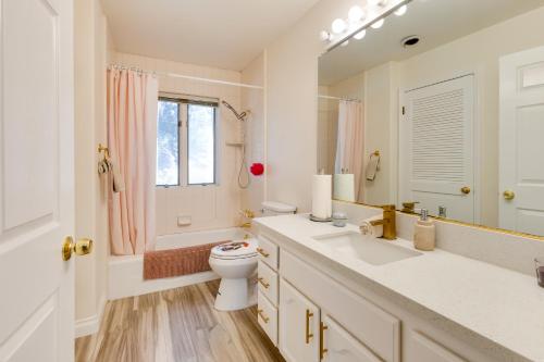 Un baño con inodoro, lavabo y espejo. en Game Room and Deck Modern Frazier Park Home!, en Pine Mountain Club