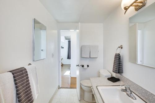 a white bathroom with a sink and a toilet at 3 Mi to Balboa Park Water-View Condo with Balcony in San Diego