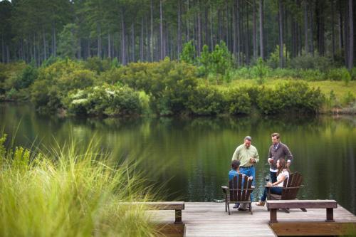 a group of people standing on a dock near a lake at Signature 5 Bedroom Lagoon Residence 1003 in Bluffton