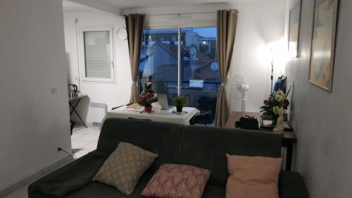 un salon avec un canapé vert et une table dans l'établissement Centre, Grand T2 balcon Pkg, plage gare 600m, Trés calme, à Arcachon