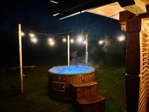 a hot tub in a yard at night with lights at Sielankowe Pole in Józefów