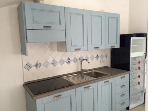 a kitchen with white cabinets and a sink at Summer Holidays Apartments in Foce Varano