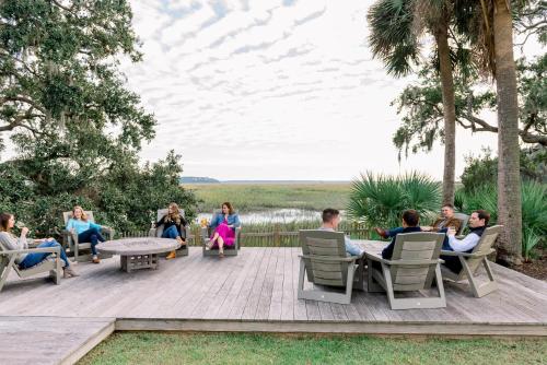a group of people sitting on a wooden deck at Signature 5 Bedroom Lagoon Residence 1003 in Bluffton