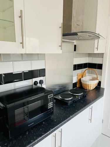 a kitchen with a black microwave and a counter at Home Sweet Home Studio in Foleshill