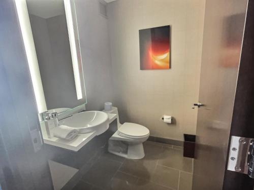 a bathroom with a white toilet and a sink at Jet Luxury at The Vdara in Las Vegas