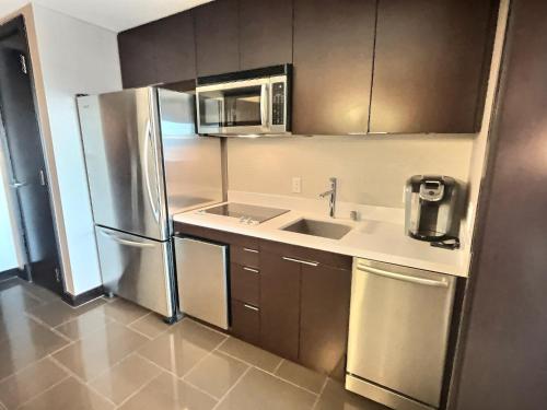 a kitchen with a stainless steel refrigerator and a sink at Jet Luxury at The Vdara in Las Vegas