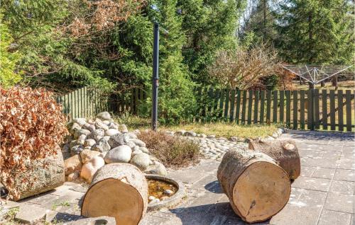 a garden with logs and rocks and a fence at Holiday Home Rørvig 01 in Rørvig