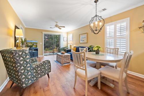 a dining room and living room with a table and chairs at 53B Blue Wedge at True Blue condo by Peace Vacations in Pawleys Island