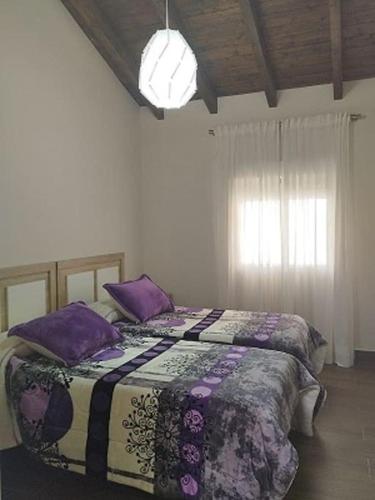 a bedroom with a bed with purple pillows at Casa Bonaire in Chella