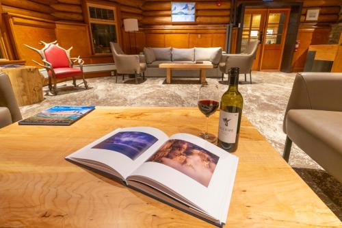 a book and a bottle of wine on a table at The Lodge at Bow Lake in Lake Louise