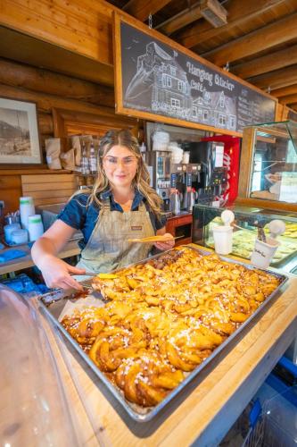 a woman standing behind a counter with a tray of food at The Lodge at Bow Lake in Lake Louise