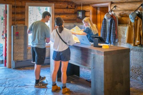 a man and a woman standing at a cash register at The Lodge at Bow Lake in Lake Louise