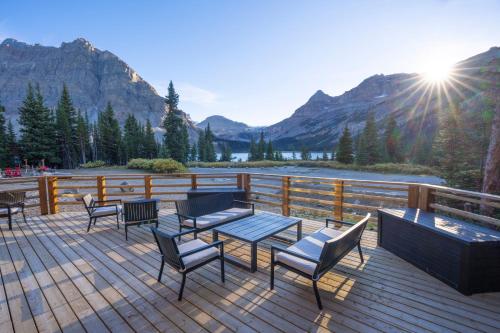 a deck with chairs and tables and a view of a mountain at The Lodge at Bow Lake in Lake Louise