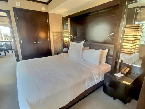 a bedroom with a large white bed and a table at Jet Luxury at The Vdara in Las Vegas