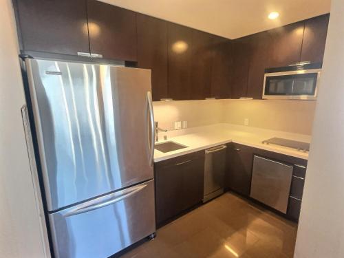a kitchen with a stainless steel refrigerator and cabinets at Jet Luxury at The Vdara in Las Vegas