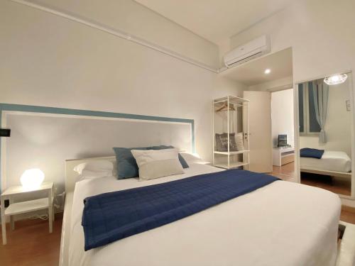 a bedroom with a blue and white bed and a desk at Mazzini 12, Elegant Central Apartment, Air Conditioning, Wi-Fi, Just 100 mt from the Public Beach, the Ideal Choice for a Relaxing and Exciting Coastal Escape, private garage available on request at 20,00 per night in Rapallo