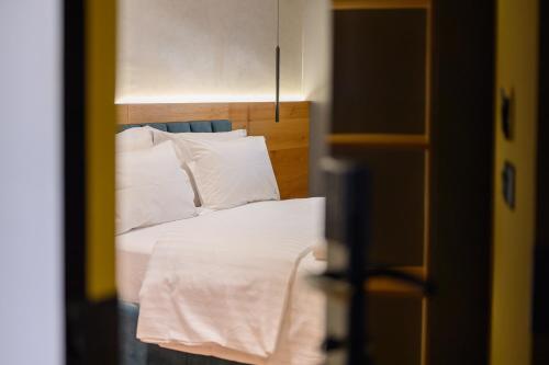 a bedroom with a bed with white sheets and pillows at Adore Home in Tirana