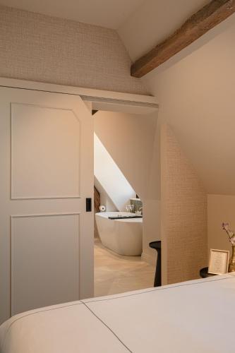 a bedroom with a white door and a bath tub at Boutiquehotel Le Foulage - adults only in Bruges