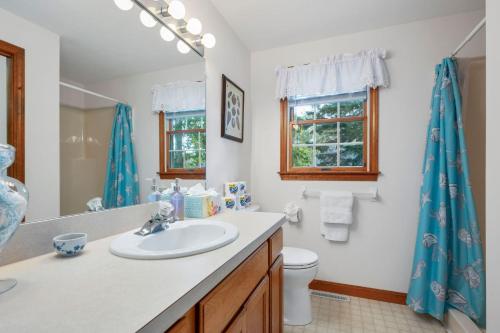 Un baño con lavabo, inodoro y espejo. en 11 Lucaya Lane Harwich Port - Woods Edge, en Harwich Port