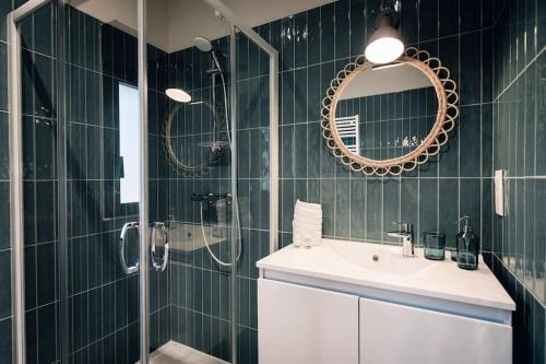 une salle de bain avec un lavabo, une douche et un miroir dans l'établissement Maison des Dunes, à Saint-Julien-en-Born