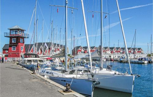 a group of boats docked in a marina with a lighthouse at Apartment Færgevej X in Bagenkop