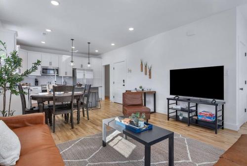 a living room with a couch and a tv and a kitchen at Duplex with Balcony and Spacious Dog-Friendly Oasis! in Richmond