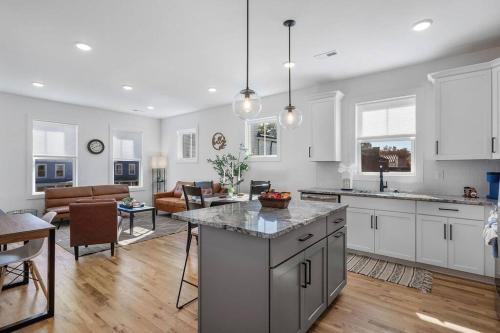 a kitchen with white cabinets and a living room at Duplex with Balcony and Spacious Dog-Friendly Oasis! in Richmond