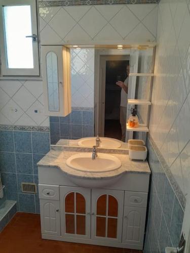 - une salle de bains avec deux lavabos et une personne dans le miroir dans l'établissement Appartement 3 ch proche Lydia, au Barcarès