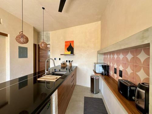 a kitchen with a sink and a counter top at Chichén 27 Departamentos nuevos con piscina cerca de Ferry a Isla Mujeres in Cancún