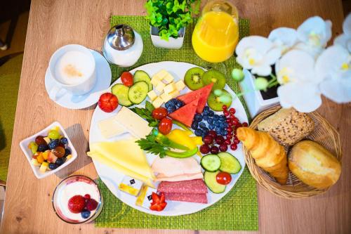 a table topped with a plate of cheese and fruit at Hotel Emmerich in Winningen