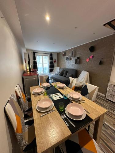 un salon avec une table et un canapé dans l'établissement Loc'apparts, à Beaumont-sur-Oise